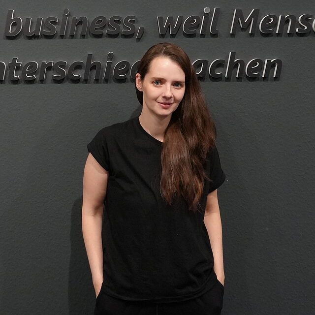 Bianca Raković, Consultant bei P-P-D, vor dem P-P-D-Schriftzug im Büro in Eschweiler